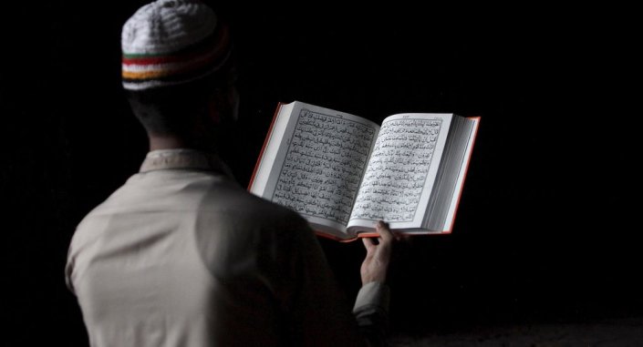 Hombre leyendo el Coran