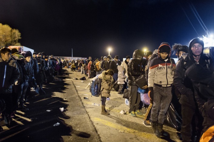 Refugiados y migrantes esperan para abordar un ferry que los lleve a Atenas en el Puerto de Mitilene en Lesbos.