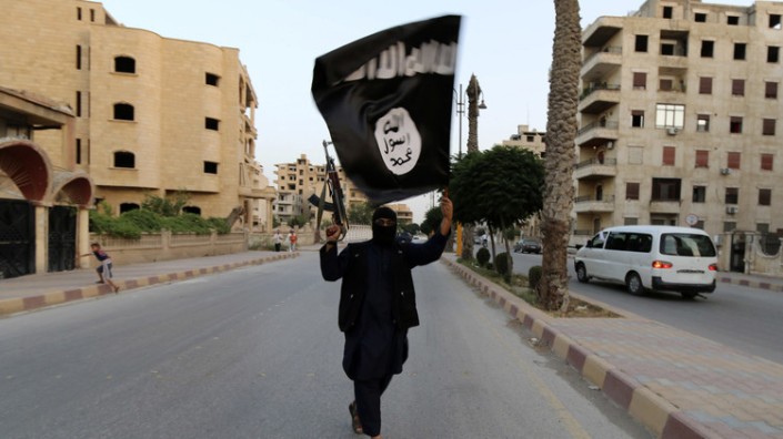 Un miembro del Estado Islámico con una bandera de la organización terrorista en la localidad siria de Raqa el 29 de junio de 2014